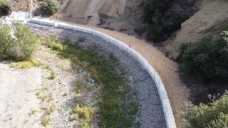 Vue de l’ouvrage achevé et de la zone de dépôts en arrière de la réhausse